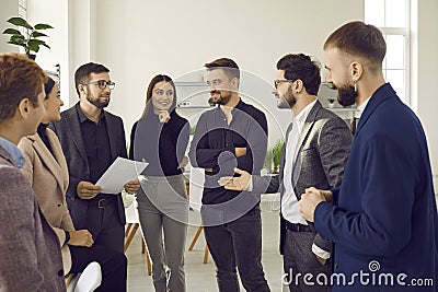Group of business people chatting after a meeting. Company employees talking in the office. Stock Photo