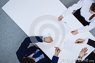 Group of business people and lawyer discussing contract papers sitting at the table, view from above. Businessman is Stock Photo