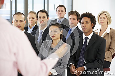 Group Of Business People Listening To Speaker Giving Presentation Stock Photo