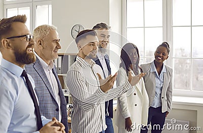 Group of business people listening to their colleague or their leadership in office. Stock Photo