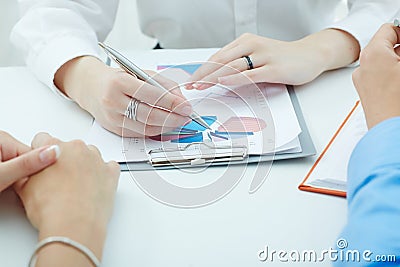 Group of business people looking at the clipboard with graphics. Stock Photo