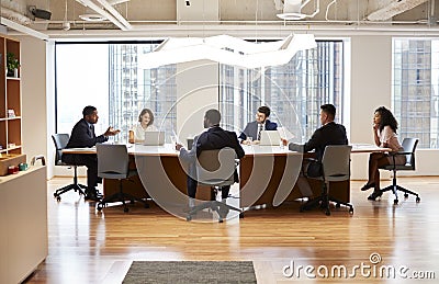Group Of Business Professionals Meeting Around Table In Modern Office Stock Photo