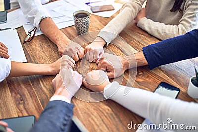 Group of business workers standing bumping fists at the office Stock Photo