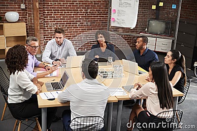 Group Of Businessmen And Businesswomen Meeting Around Office Table Stock Photo