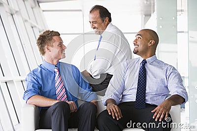 Group of businessmen talking in lobby Stock Photo