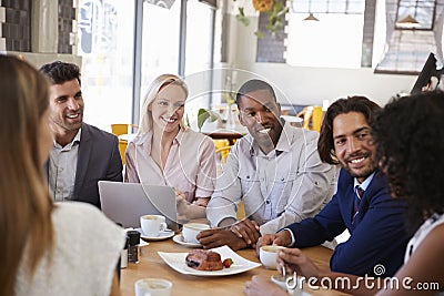 Group Of Businesspeople Having Meeting In Coffee Shop Stock Photo