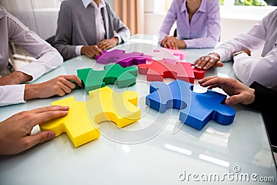 Group Of Businesspeople Solving Jigsaw Puzzle Stock Photo