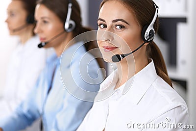Group of callcenter operators at work. Focus at beautiful business woman in headset Stock Photo