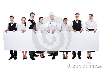 Group of catering staff holding a blank banner Stock Photo