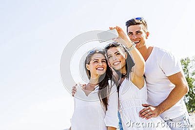 Group of cheerful and beautiful young people taking photos of th Stock Photo