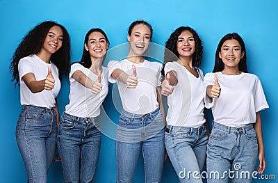 Group Of Cheerful Ladies Gesturing Thumbs-Up On Blue Studio Background Stock Photo
