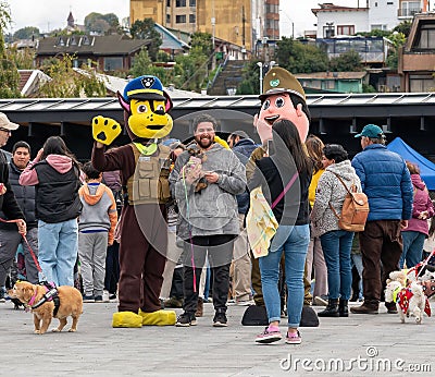 Group of cheerful mascots dressed in military uniforms on the street with people in the background Editorial Stock Photo