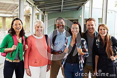 A group of cheerful teachers hanging out in school corridor Stock Photo