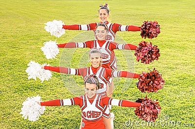 Group of cheerleaders in action with female coach Stock Photo