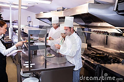 Group of chef preparing food in commercial kitchen Stock Photo