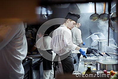 Group of chef preparing food in the kitchen of a restaurant Stock Photo