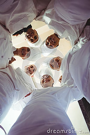 Group of chefs formig huddles in kitchen Stock Photo