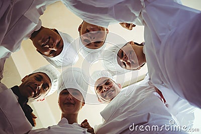 Group of chefs formig huddles in kitchen Stock Photo