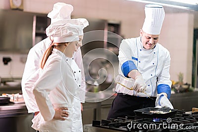 A group of chefs preparing delicious meal in high luxury restaurant. Stock Photo