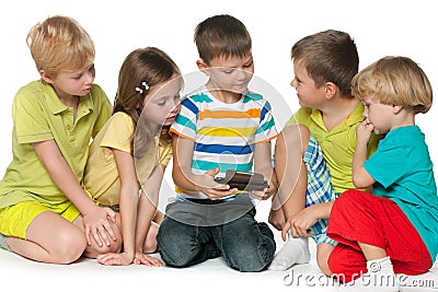 Group children plaing with a new gadget Stock Photo