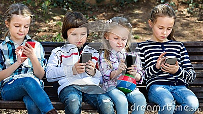 Group of children posing with mobile devices Stock Photo