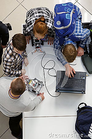 Group of children programming the robot at robotics competitions. Editorial Stock Photo