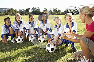 Group Of Children In Soccer Team Having Training With Female Coach Stock Photo