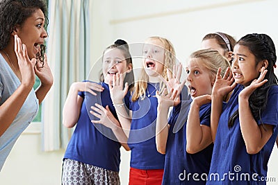 Group Of Children With Teacher Enjoying Drama Class Together Stock Photo