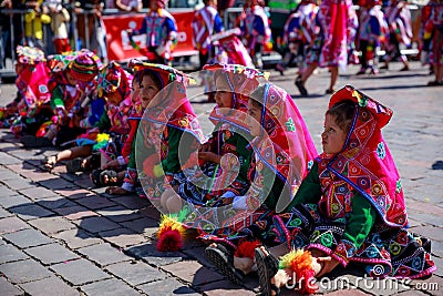 Group of children in traditional Peruvian dresses, sitting on the street Editorial Stock Photo