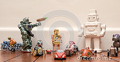 Group of childrens vintage and retro style toys including cars and robots on a wooden floor Editorial Stock Photo