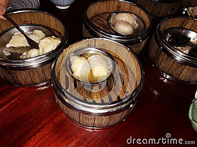 Group of Chinese dumpling in bamboo steamer box on brown wooden table Stock Photo