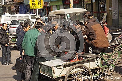 Group of chinese men enjoying talking and playing a game after workin hours in a street in Beijing, China. Editorial Stock Photo