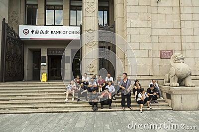 Group of Chinese tourists taking rest at the stairs of Bank of China entrance Editorial Stock Photo