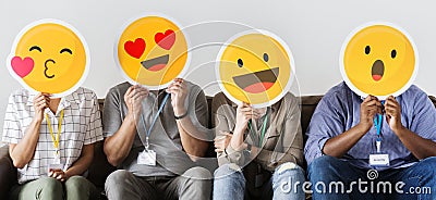 Group of co-workers holding emoticons Stock Photo