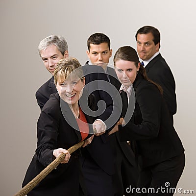 Group of co-workers pulling rope in tug-of-war Stock Photo