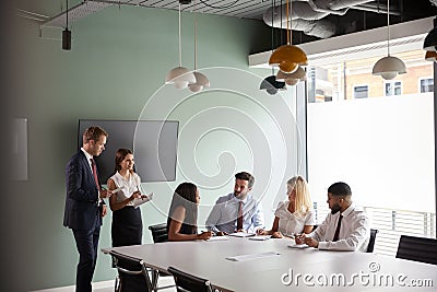 Group Collaborating On Task At Graduate Recruitment Assessment Day Whilst Being Observed By Recruitment Team Stock Photo