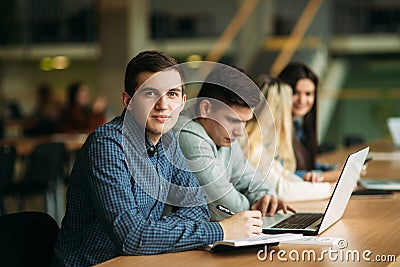 Group of college students studying in the school library, a girl and a boy are using a laptop and connecting to internet Stock Photo