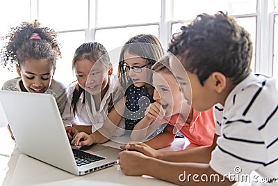 Group of curious children watching stuff on the laptop screen Stock Photo