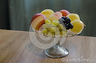 A group of different fresh ripe fruits - apple, peach, grapes and pears in a fruit bowl Stock Photo