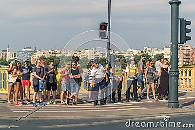 A group of different people is waiting for a pedestrian traffic light. Editorial Stock Photo