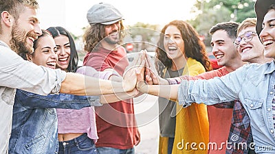 Group of diverse friends stacking hands outdoor - Happy young people having fun joining and celebrating together Stock Photo