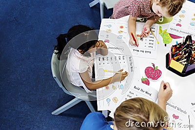 Group of diverse Kids coloring workbook in class Stock Photo