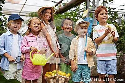 Group of diverse kindergarten kids friends in garden, greenhouse Stock Photo