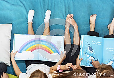 Group of Diverse Young Students Reading Children Story Book Together Stock Photo