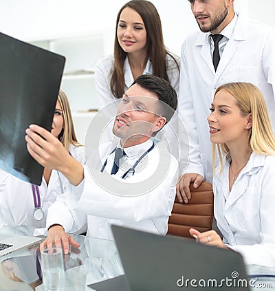 Group of doctors discussing an x-ray ,sitting at the table. Stock Photo