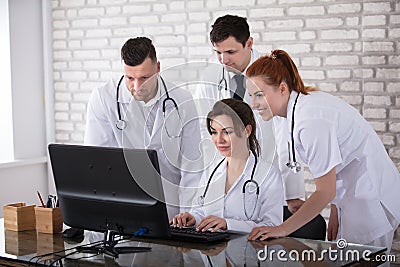 Group Of Doctors Looking At Computer Stock Photo