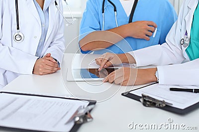 Group of doctors at medical meeting. Close up of physician using touch pad or tablet computer Stock Photo