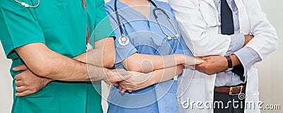 Group of doctors and nurses holding hands together in a medical team . Cooperation Stock Photo