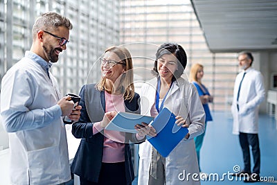 Group of doctors talking to pharmaceutical sales representative. Stock Photo