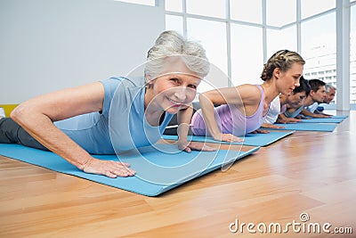 Group doing cobra pose in row at yoga class Stock Photo